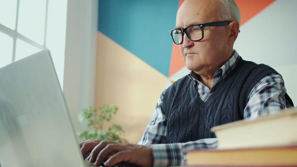 Mandlig senior ved computer